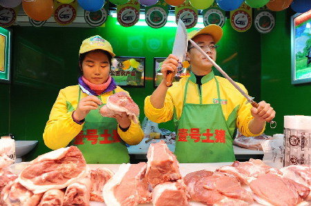 　2013年1月29日，上海天山路585弄澳华菜市场，江西财经大学本科毕业生郝承兵（右）与海南大学本科生孙夏（左）在“壹号土猪”柜台上工作。 