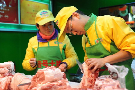 　2013年1月29日，上海天山路585弄澳华菜市场，江西财经大学本科毕业生郝承兵（右）与海南大学本科生孙夏（左）在“壹号土猪”柜台上工作。
