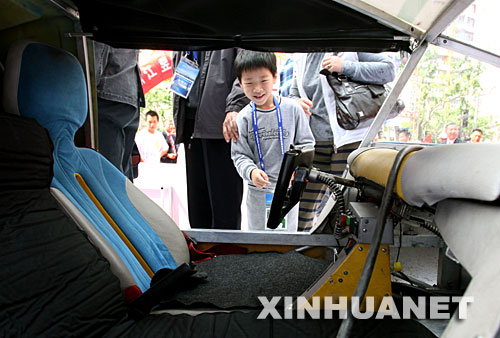 5月10日，一名小观众在参观太阳能汽车。 正在上海举行的“2008国际太阳能光伏大会”上，一辆太阳能汽车亮相。这是世界上第一个以太阳能为动力进行环球旅行的交通工具。瑞士人路易斯·帕尔马驾驶这辆汽车于2007年7月3日从瑞士卢塞恩出发，计划在18个月内跨越5大洲50个国家。中国是这次旅行的第25站。 新华社记者 刘颖 摄 