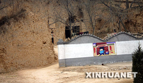 这是淳化县在国道旁农民破旧的土窑外修建的“风景墙”，农民将这“风景墙”称为“遮羞墙”（摄于3月5日）。 陕西省咸阳市地处西部欠发达地区，目前尚未完全摆脱贫困，有的村民连吃水难、行路难问题还没有解决。然而，这里的一些乡村热衷于建广场、立雕塑、修花坛、移大树，花费巨额资金“打造”新农村“示范村”，还有的乡村为了应付领导参观修遮羞墙、建仿古门，甚至毁良田、挖果园建新村。