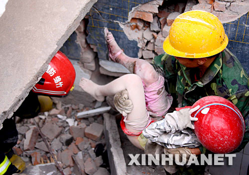  5月13日，救护人员在抢救被困学生。 四川绵竹市汉旺镇武都小学的教学楼在地震中倒塌，众多师生被埋在倒塌的校舍中。救援行动正在积极展开。