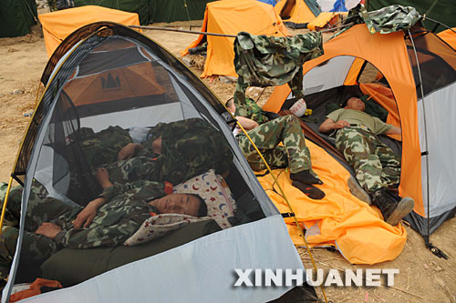 5月17日，在汶川地震重灾区北川县，从陈家坝抢险归营的武警官兵抓紧时间休息，等待替换战友。 ？？？？当日是汶川地震发生后的第6天，解放军、武警官兵和预备役民兵以及社会各界的志愿者继续在各个灾区进行抢险搜救工作。 