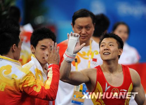  8月9日，中国选手陈一冰（右）在完成他的吊环动作后和队友杨威击掌致意。陈一冰的吊环资格赛成绩为16.525分。当日，中国队在北京奥运会体操男子资格赛第二场的比赛中，以374.675分的总成绩暂列资格赛第一。