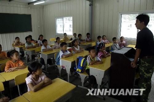 8月26日，映秀小学4年级的老师苏成刚在给学生上课。当日，汶川大地震震中地——映秀镇映秀小学在中断教学3个多月后，正式开学复课。共132名学生前来上课。其余的学生，有些还在外地治病、有些学生则已异地复课。复课的映秀小学取消了班的建制，只保留年级。汶川大地震造成映秀小学473名学生中，222人遇难、3人失踪；47名老师中，20人遇难。新华社记者 海明威 摄