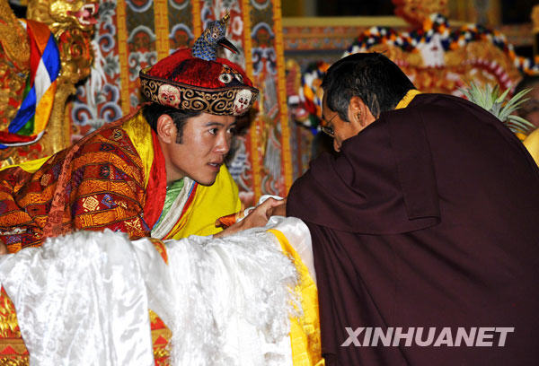 11月6日,在不丹首都廷布,不丹第五世国王吉格梅·凯萨尔·纳姆耶尔·旺楚克(左)在加冕仪式上接受祝福。不丹第五世国王吉格梅·凯萨尔·纳姆耶尔·旺楚克的加冕大礼当日在廷布举行。吉格梅·凯萨尔·纳姆耶尔·旺楚克国王现年28岁,曾在美国和英国学习,并获得牛津大学政治学硕士学位。在正式从父亲手中接过王冠之后,他成为了当今世界上最年轻的国王。 新华社记者王晔摄