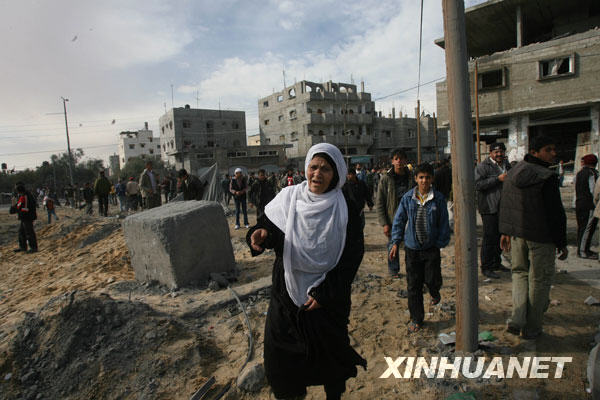 12月27日，在加沙地带南部的拉法，巴勒斯坦人在一处遭以军战机空袭的地点查看。以色列战机当日上午向加沙地带发动大规模空袭，袭击了多处巴勒斯坦伊斯兰抵抗运动（哈马斯）在加沙地带的机构，至少造成１４０名巴勒斯坦人死亡，２００人受伤。