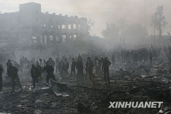  12月27日，在加沙地带南部的拉法，巴勒斯坦人在一处遭以军战机空袭的地点查看。以色列战机当日上午向加沙地带发动大规模空袭，袭击了多处巴勒斯坦伊斯兰抵抗运动（哈马斯）在加沙地带的机构，至少造成１４０名巴勒斯坦人死亡，２００人受伤。
