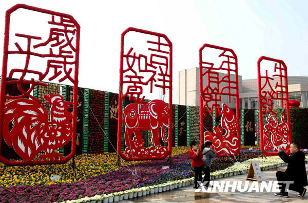 1月20日，温州市民在大型“剪纸花窗”造型景观前拍照。 