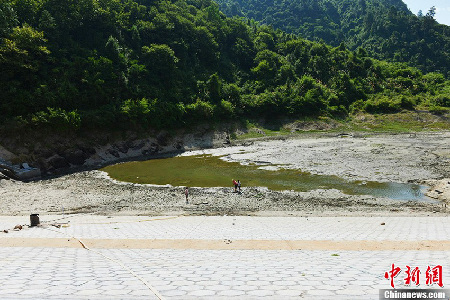 7月24日，湖南省沅陵县麻溪铺稻田缺水干裂，部分溪水断流，玉米叶黄果败。据统计，7月上旬以来，沅陵县降雨量只有20毫米，较往年同期严重偏少，导致409894亩农田受灾、155514人饮水困难。目前，沅陵县政府已组织村民们积极抗灾自救，将旱灾损失降到最低。图为肖家坳村水库是一座小Ⅱ型水库，平时水容积量有16.8万立方米，如今只剩下1万立方米。郑佳 摄