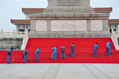 9月28日，北京，为迎接首个烈士纪念日，人民英雄纪念碑四周已铺上红地毯。图为环卫工人进行清扫保洁。 图/CFP