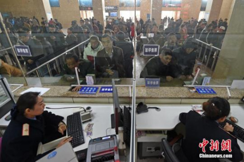 资料图：山西太原火车站售票大厅，工作人员在向旅客发售车票。 中新社记者 武俊杰 摄