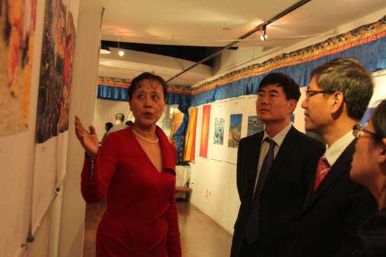 中国驻纽约总领馆副总领事钟瑞明正在聆听工作人员介绍展览内容。