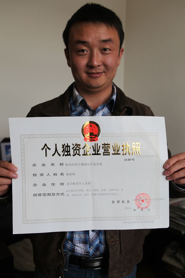 工商局工作人员将“海南州龙羊湖家庭生态农场”营业执照送到杨添铭手中。