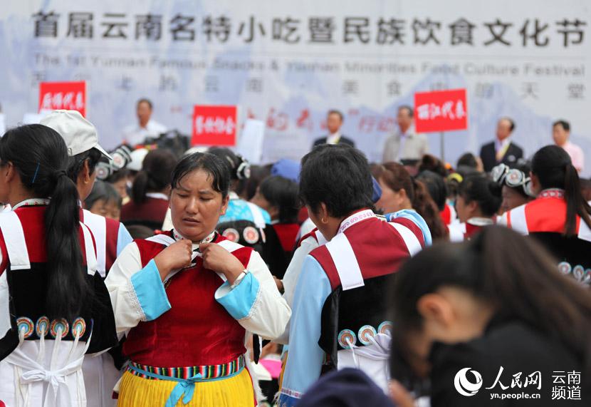 丽江玉龙县纳西族妇女在活动现场整理着装，等待首届云南名特小吃暨民族饮食文化节开幕。摄影：赵文瑞