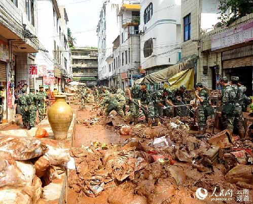 武警官兵正在清扫淤泥。（华坪县政府新闻办 供图）
