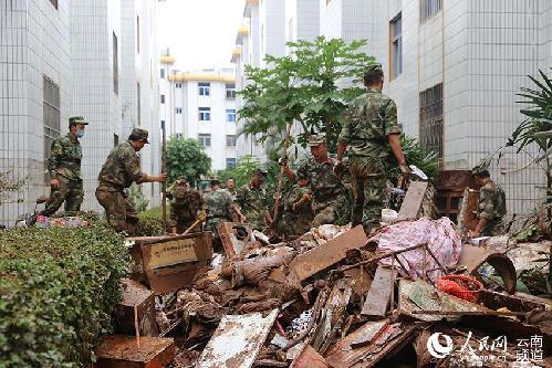武警官兵正在清扫淤泥。（华坪县政府新闻办 供图）